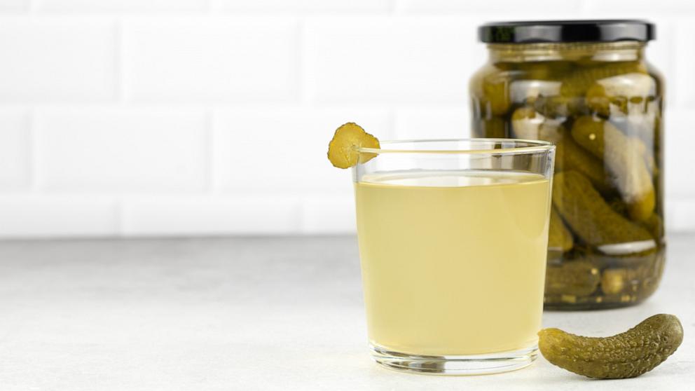 PHOTO: Brine in a glass and jar of pickled cucumbers in an undated photo