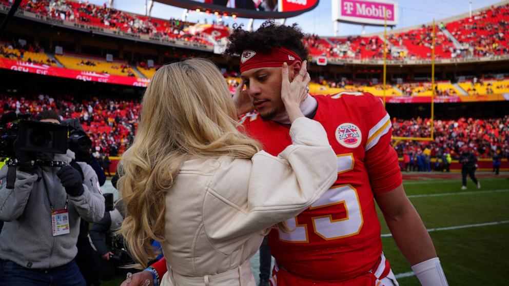 PHOTO: Kansas City Chiefs quarterback Patrick Mahomes (15) kisses his wife Brittany Mahomes before a 2025 AFC divisional round game against the Houston Texans at GEHA Field at Arrowhead Stadium, Jan. 18, 2025.