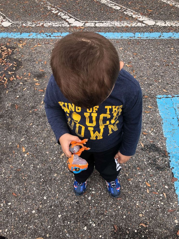 PHOTO: Jordan holds his broken dinosaur toy outside Best Buy.