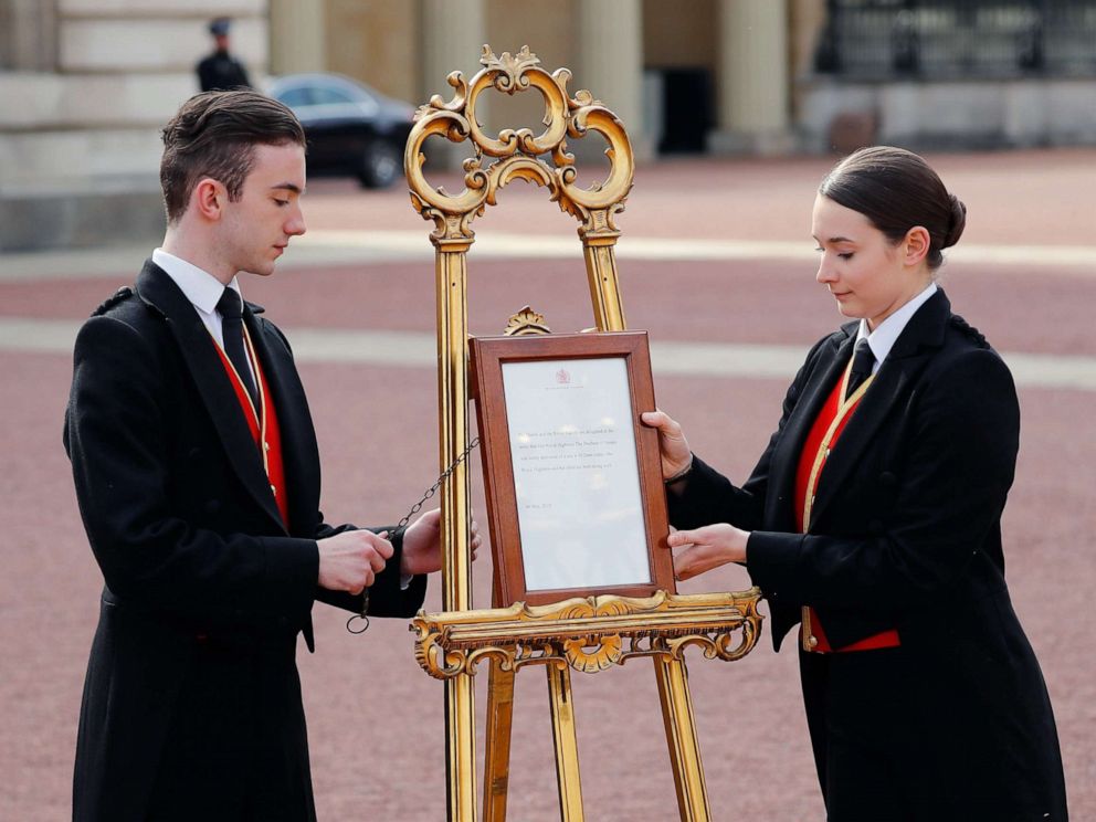PHOTO: Members of staff set up an official notice on an easel at the gates of Buckingham Palace in London on May 6, 2019 announcing the birth of a son to Britains Prince Harry, Duke of Sussex and Meghan, Duchess of Sussex.