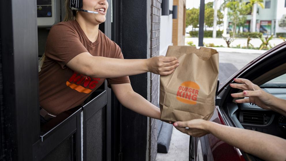 PHOTO: A worker hands food to a customer at the drive-thru window of a Burger King fast food restaurant in Hialeah, Florida, April 18, 2024.