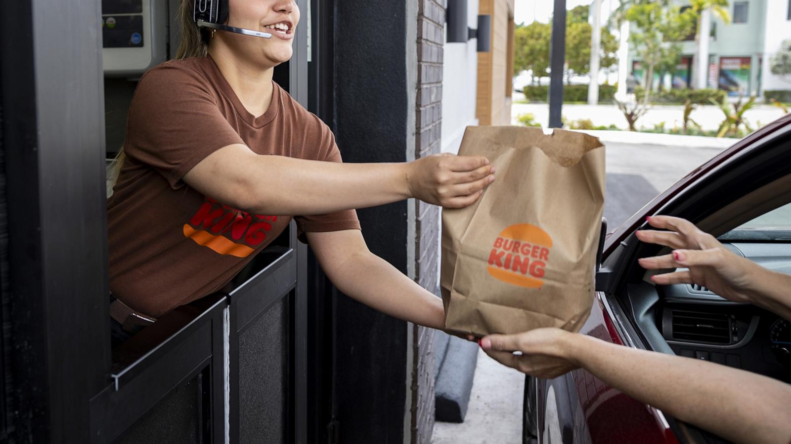 PHOTO: A worker hands food to a customer at the drive-thru window of a Burger King fast food restaurant in Hialeah, Florida, April 18, 2024.