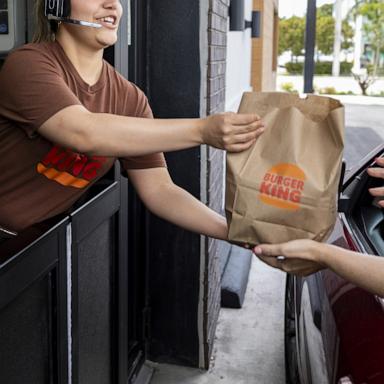 PHOTO: A worker hands food to a customer at the drive-thru window of a Burger King fast food restaurant in Hialeah, Florida, April 18, 2024.