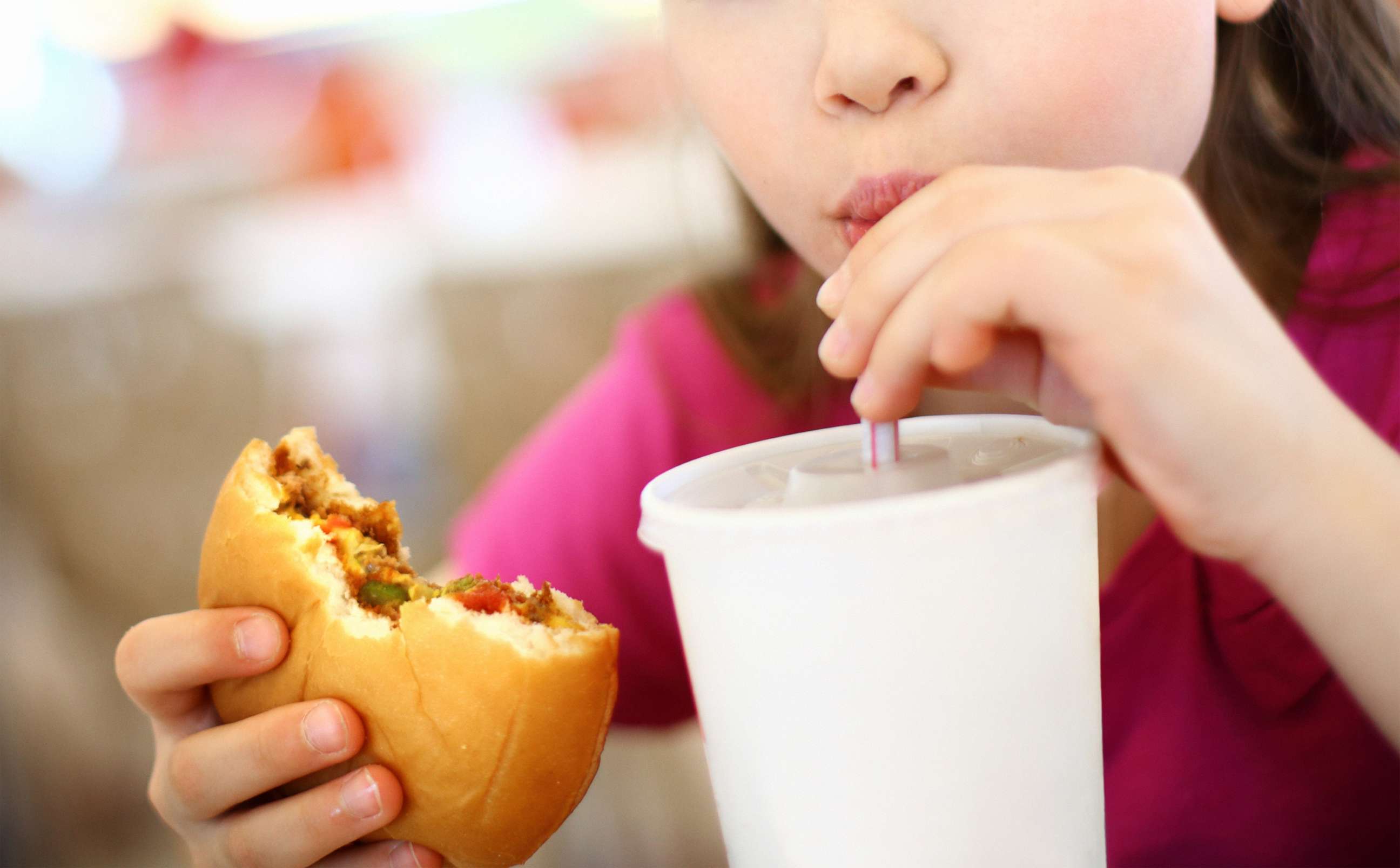 PHOTO: A girl eats a burger with a drink in this undated stock photo.