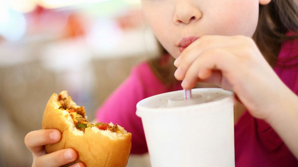 PHOTO: A girl eats a burger with a drink in this undated stock photo.
