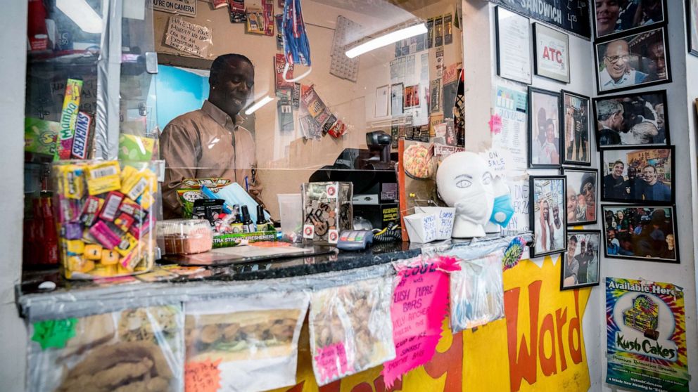 PHOTO: Burnell Cotlon, owner of Burnell's Lower Ninth Ward Market works behind the register in New Orleans on April 14, 2020.