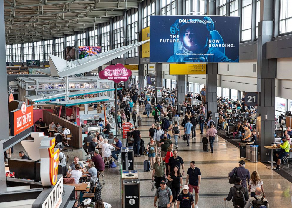 PHOTO: Travelers walk through the junction of the east and west airport terminals on May 23, 2022, in Austin, Texas.