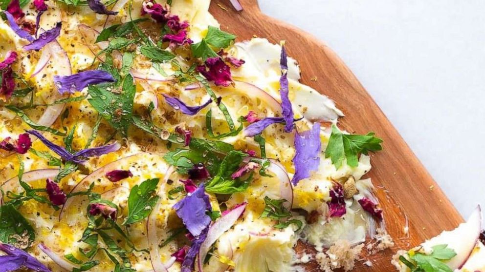 PHOTO: A butter board made with softened butter and topped with salt, lemon zest, herbs and edible flowers.