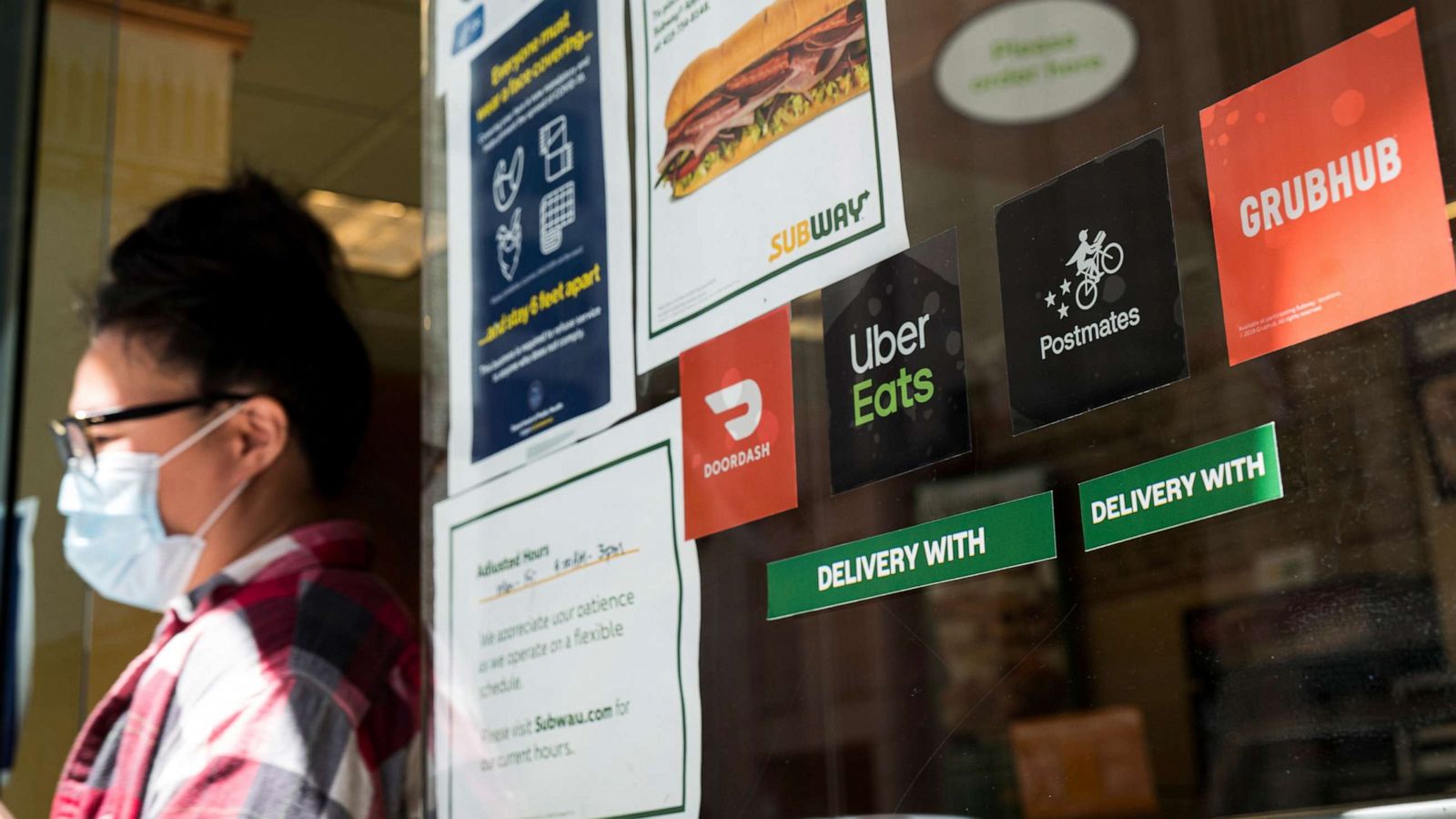 PHOTO: DoorDash, Uber Eats, Postmates and GrubHub signage is displayed in the window of a Subway Restaurant in San Francisco, July 7, 2020.