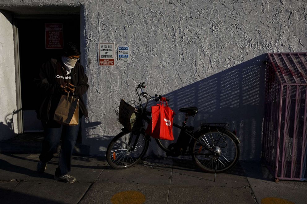 PHOTO: A DoorDash Inc. bag hangs on a bicycle as a food delivery courier picks up an order from a restaurant in Los Angeles, July 6, 2020.