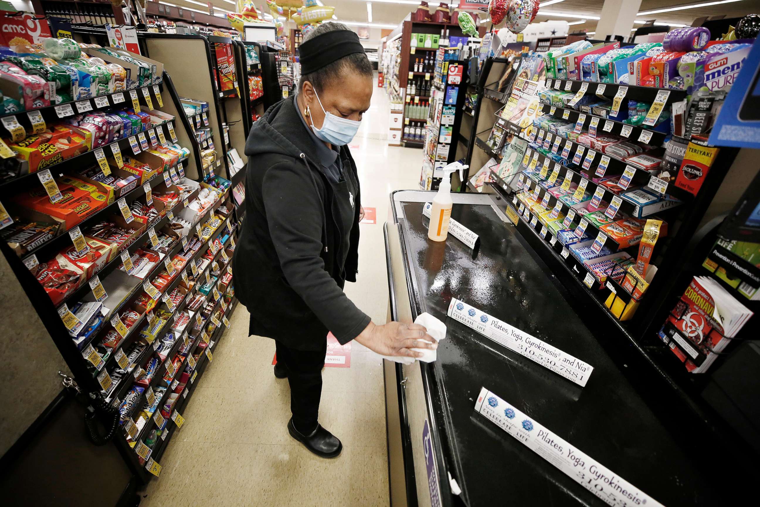 PHOTO: A cashier sanitizes a checkout lane with candy rack displays available at a Vons supermarket in Torrance, Calif., April 27, 2020.
