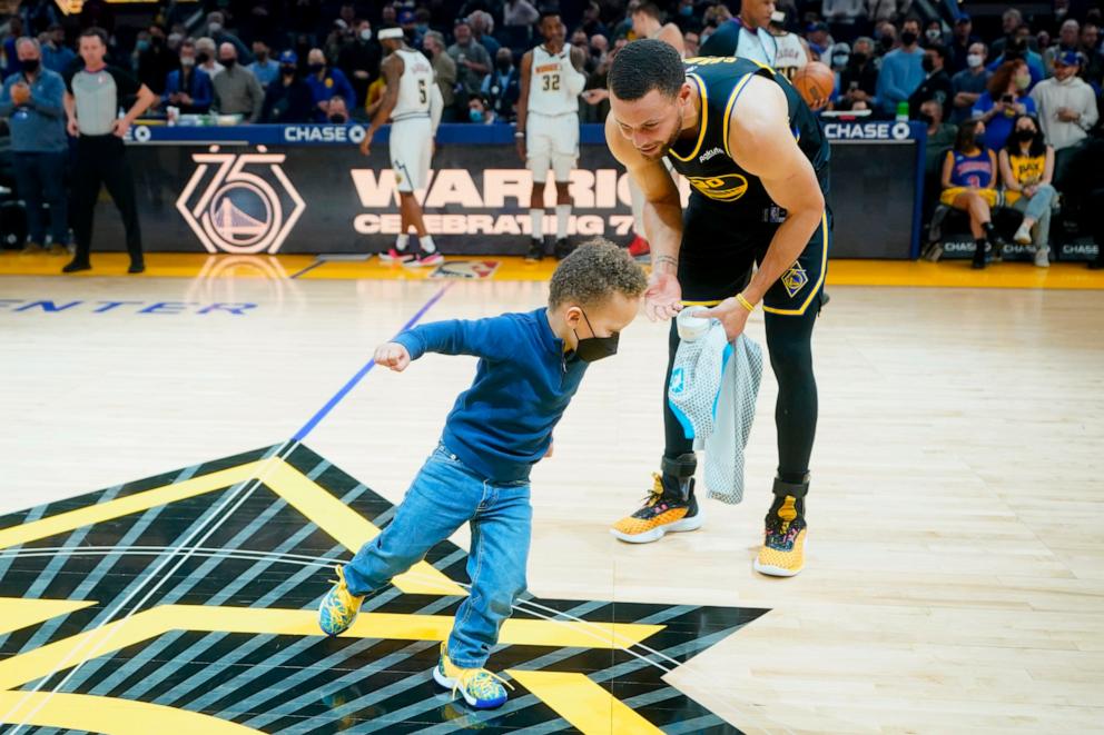 PHOTO: In this Feb. 16, 2022 file photo, Stephen Curry watches his son, Canon Curry, run on the floor after being presented an All-Star Game ring and jersey before a game between the Warriors and the Denver Nuggets in San Francisco.