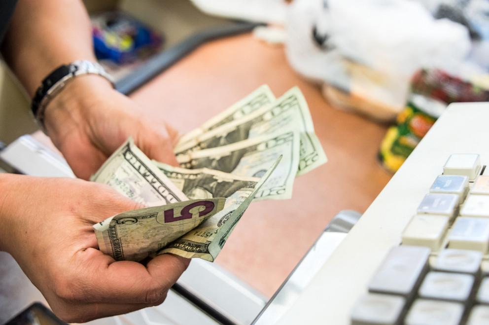 PHOTO: In this undated stock photo, a convenient store cashier counts money at the counter. 