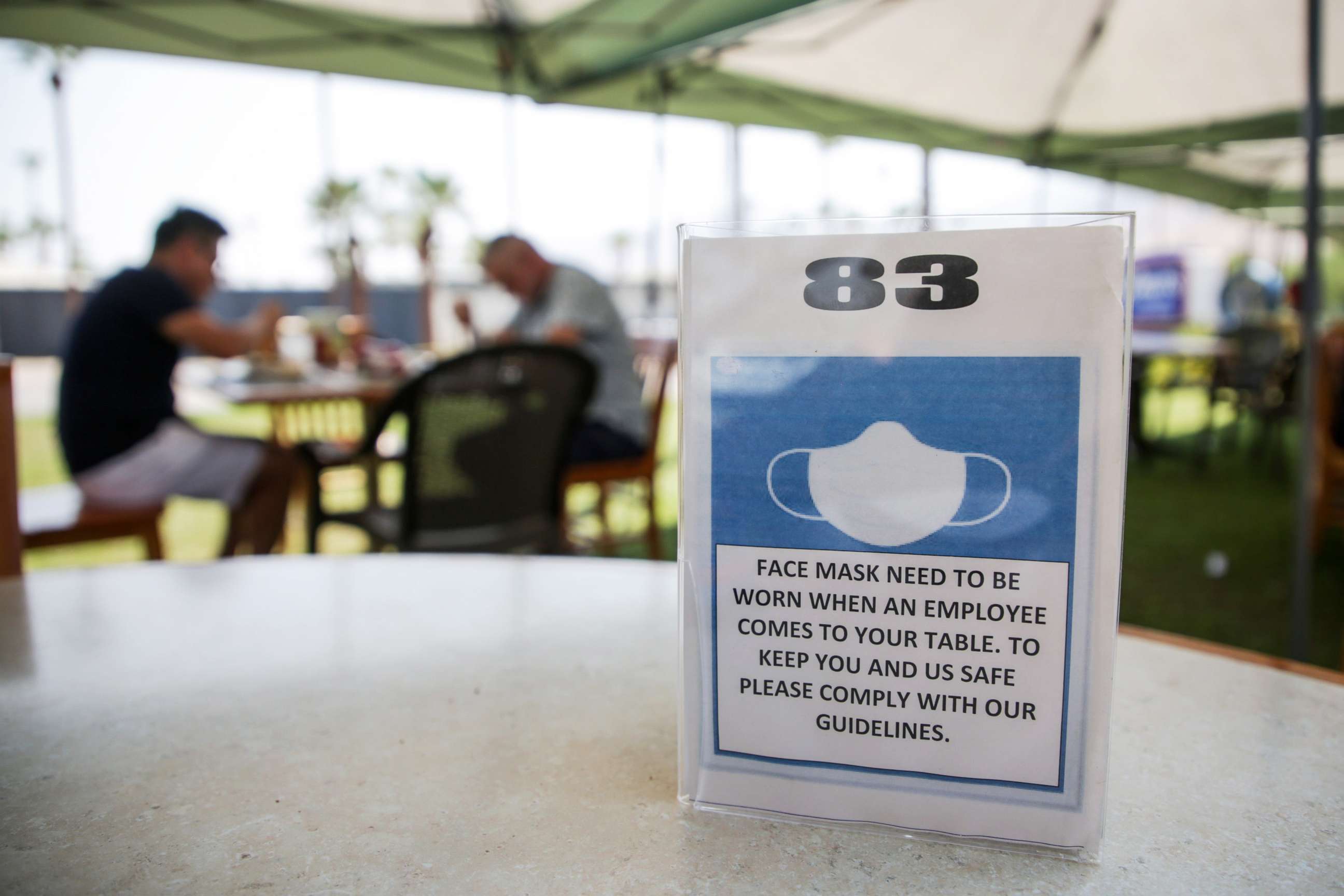 PHOTO: A sign informs customers to wear a mask while dining on the patio at Elmer's Restaurant in Palm Springs, Calif., Sept. 2, 2020.