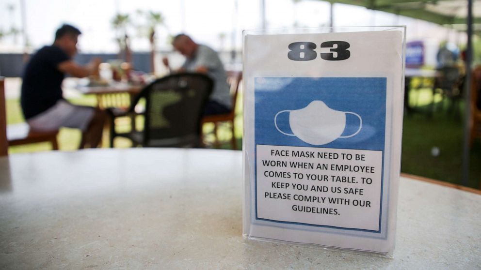 PHOTO: A sign informs customers to wear a mask while dining on the patio at Elmer's Restaurant in Palm Springs, Calif., Sept. 2, 2020.