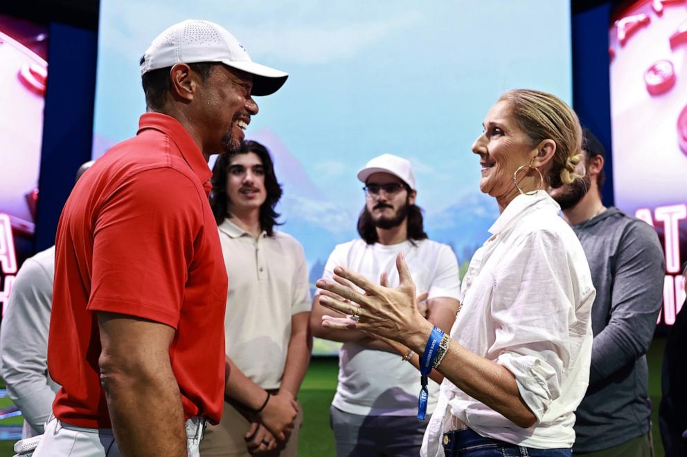 PHOTO: Tiger Woods of Jupiter Links Golf Club talks with singer Celine Dion after their TGL presented by SoFi match against the Atlanta Drive GC at SoFi Center on March 04, 2025 in Palm Beach Gardens, Florida.