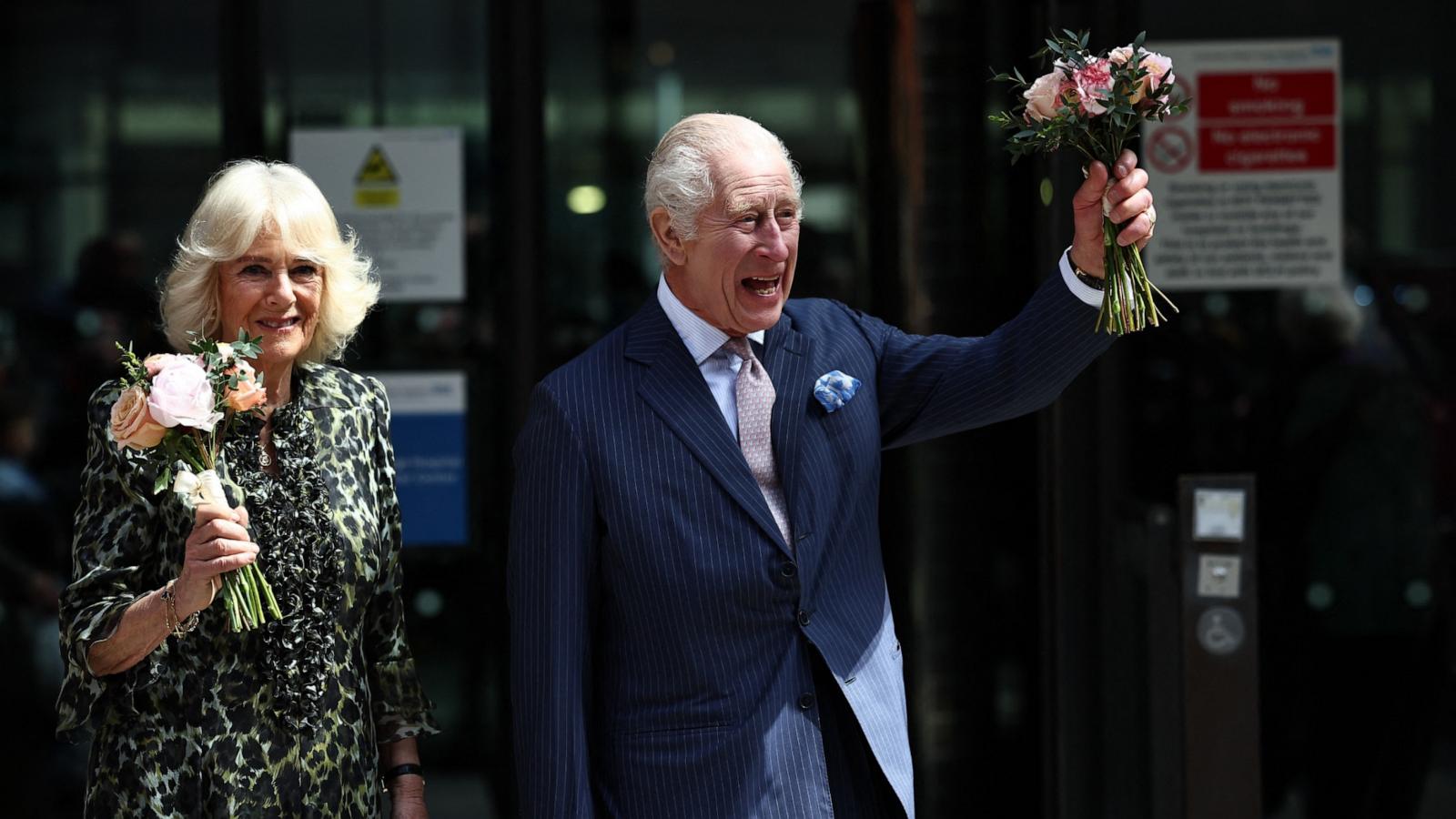 PHOTO: Britain's King Charles III and Britain's Queen Camilla, holding bunches of flowers, wave to crowds after to visit to the University College Hospital Macmillan Cancer Centre in London on April 30, 2024.