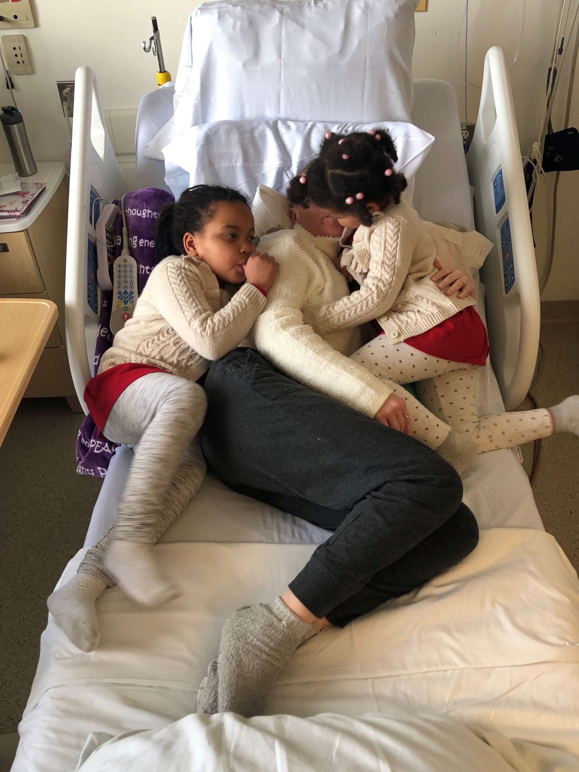 PHOTO: Charlotte Ngarukiye, of New Hampshire, is comforted by her two daughters while undergoing treatment for colorectal cancer.