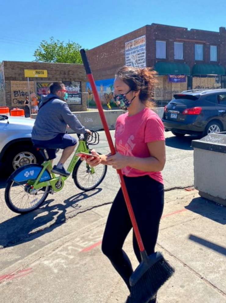 PHOTO: Dr. Gigi Chawla helps clean the streets of Minneapolis May 30 after several buildings burned down the night before.
