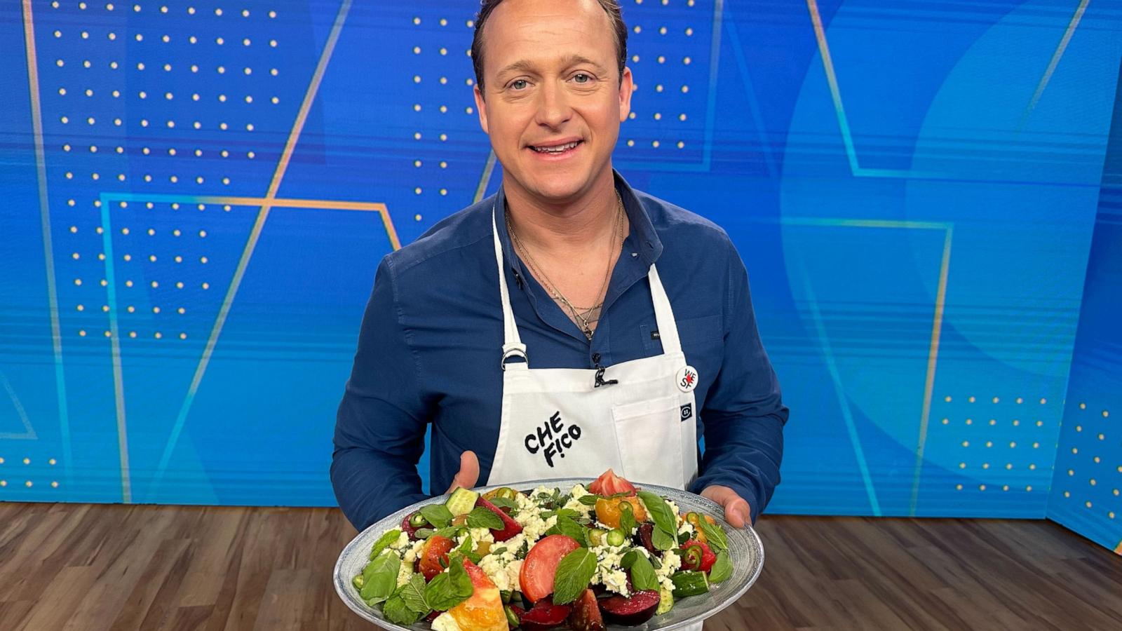 PHOTO: Chef David Nayfeld holds a plate of his summer salad with plums, tomatoes, marinated feta and fresh herbs.