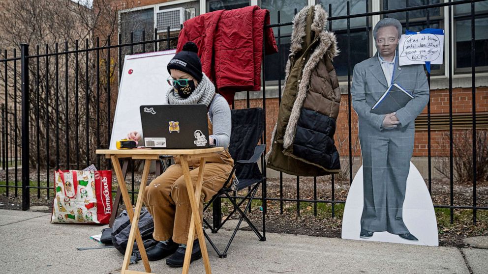 PHOTO: A teacher sets up her laptop outside of Suder Montessori Magnet Elementary School to begin virtual classes in solidarity with pre-K educators forced back into the building in Chicago, Jan. 11, 2021.