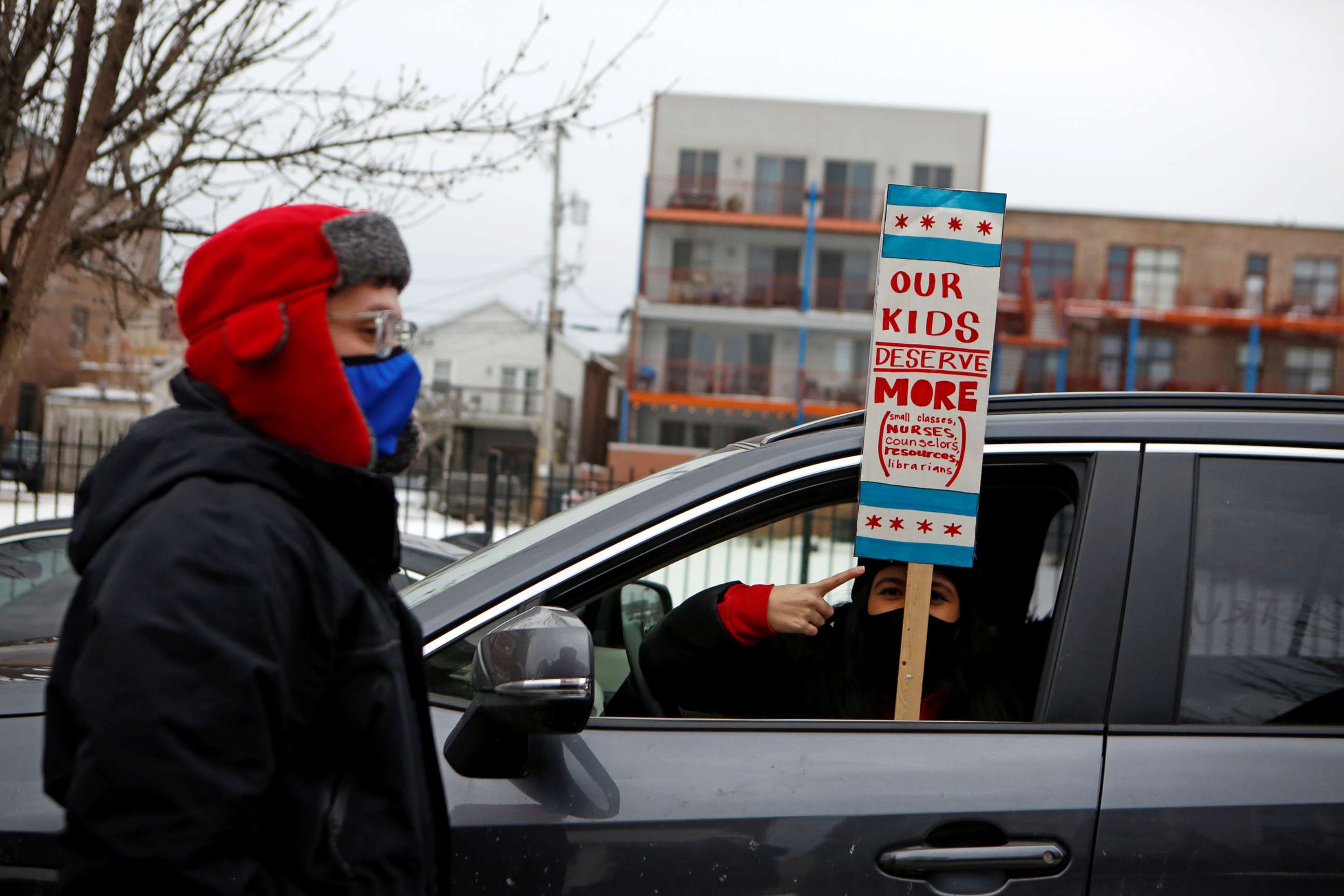 PHOTO: English Language Program teacher Marlon Henriquez and bilingual teacher Daniela Lugo prepare for a car caravan protest as union negotiations with Chicago Public Schools continue over a COVID-19 safety plan agreement in Chicago, Jan. 30, 2021.