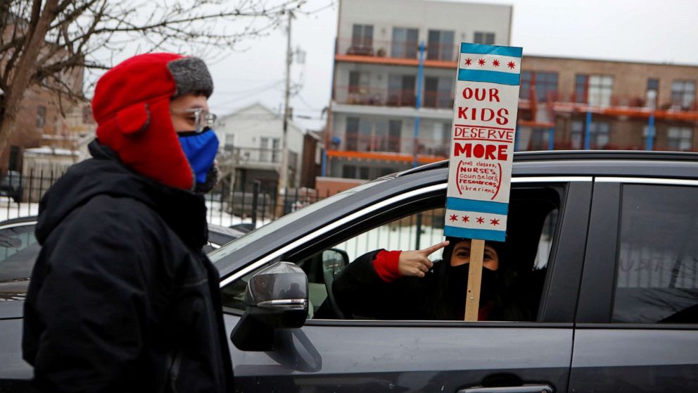 PHOTO: English Language Program teacher Marlon Henriquez and bilingual teacher Daniela Lugo prepare for a car caravan protest as union negotiations with Chicago Public Schools continue over a COVID-19 safety plan agreement in Chicago, Jan. 30, 2021.