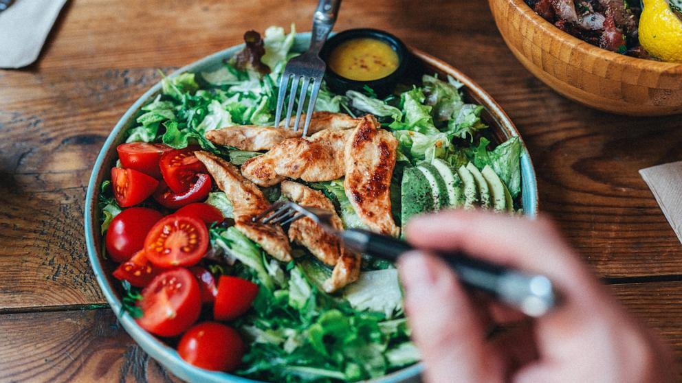 PHOTO: Stock photo of a person eating a chicken salad.