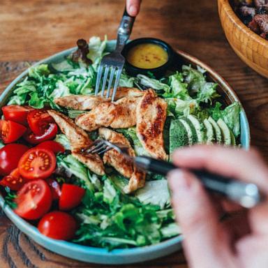 PHOTO: Stock photo of a person eating a chicken salad.