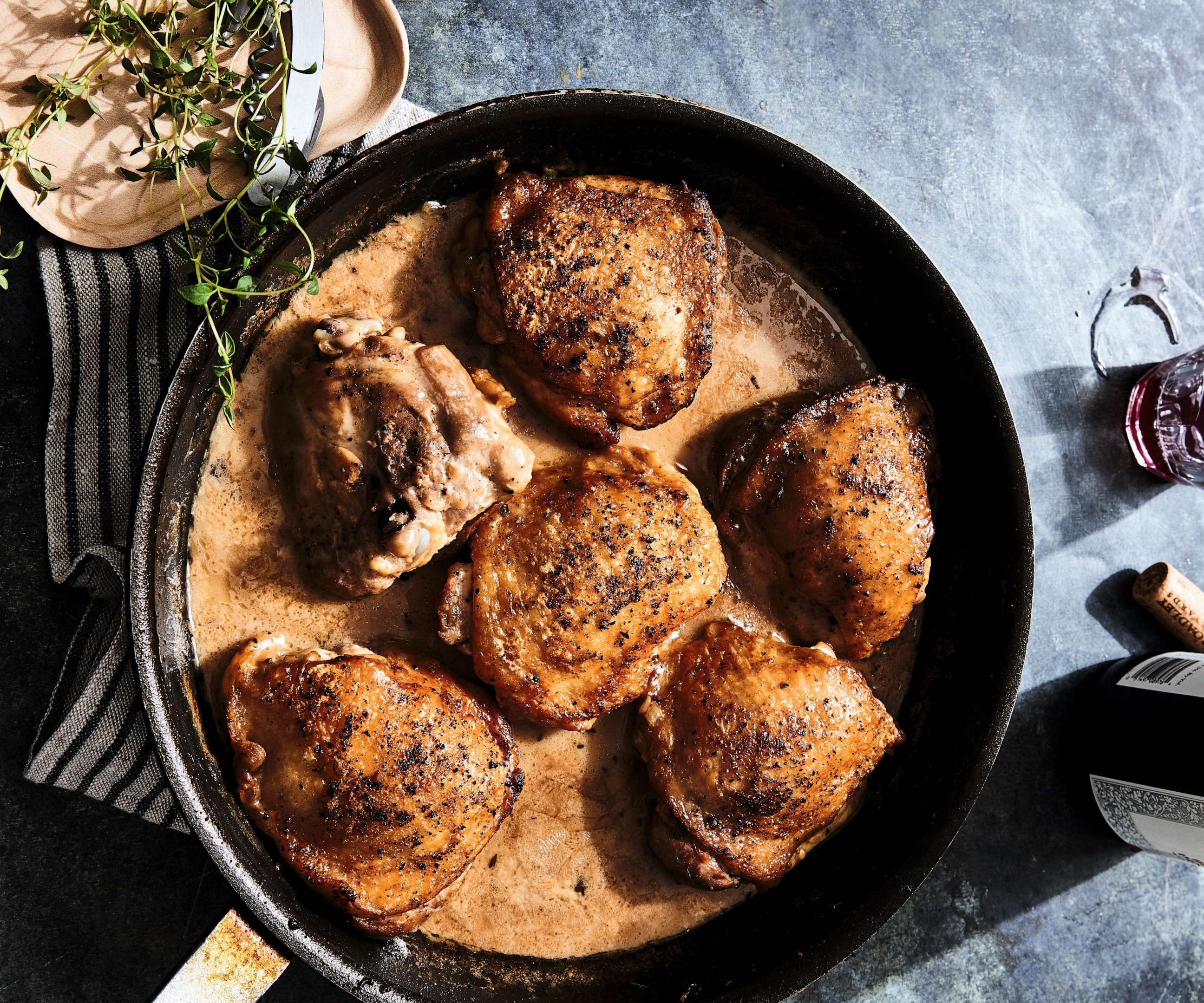 PHOTO: A cast iron skillet of roasted chicken thighs.