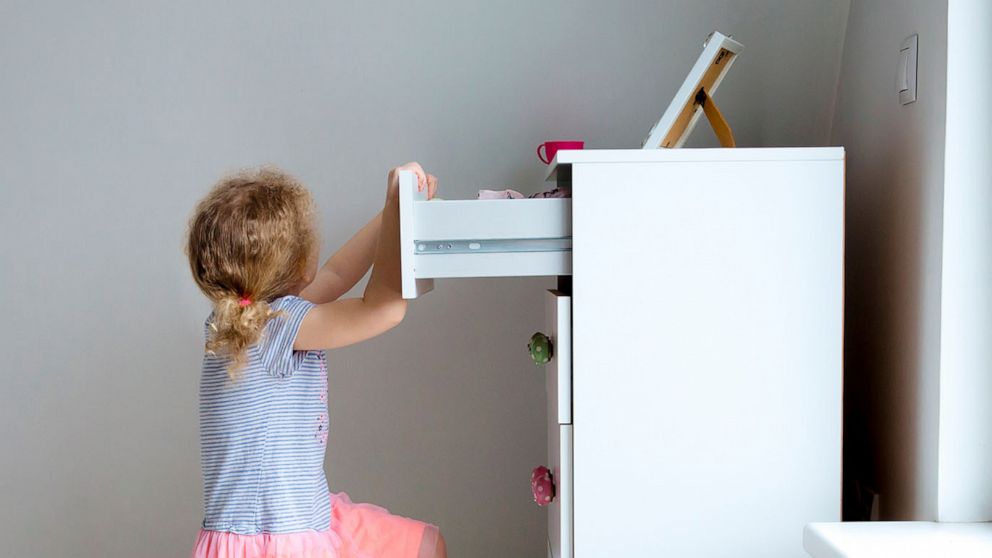 PHOTO: A young child climbs on modern high dresser furniture in an undated stock image.