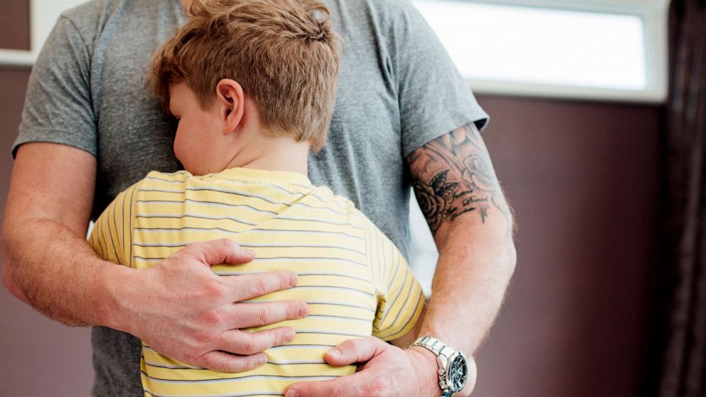 PHOTO: A little boy is hugging his father.