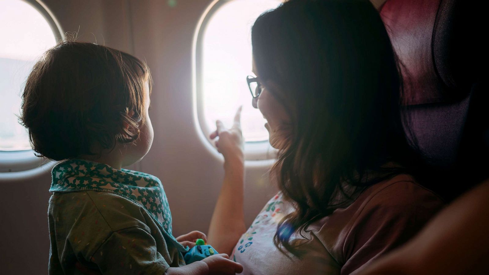 PHOTO: Stock photo of child on a parent's lap in a plane.