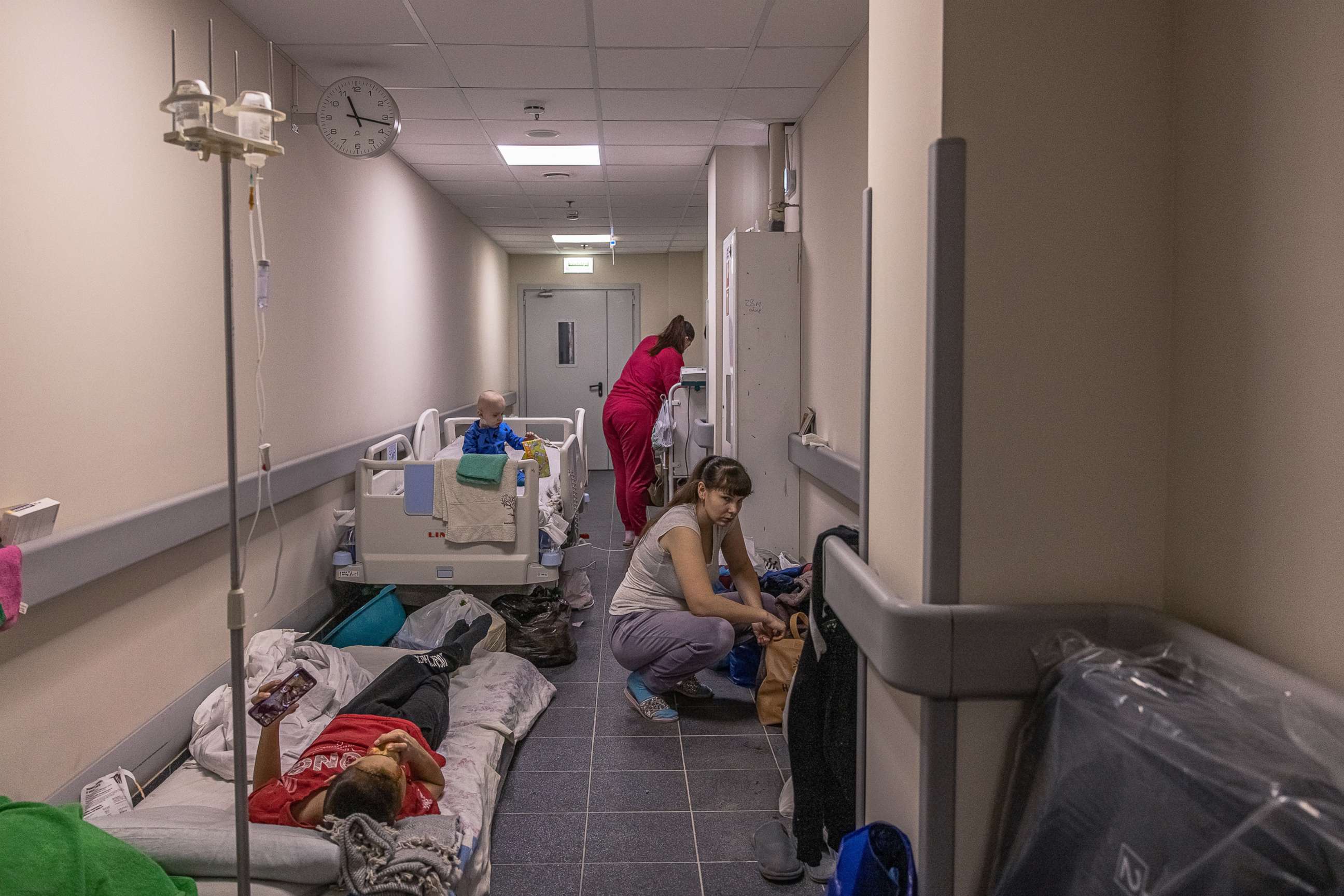 PHOTO: MParents stand next to their children being treated in the children's hospital basement, which is also being used as a shelter, March 1, 2022, in Kyiv, Ukraine.