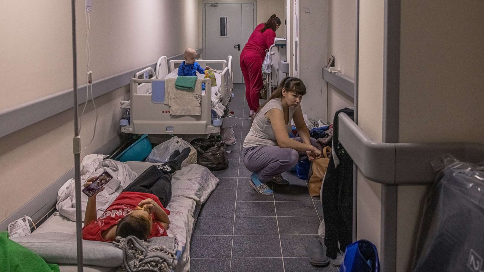 PHOTO: MParents stand next to their children being treated in the children's hospital basement, which is also being used as a shelter, March 1, 2022, in Kyiv, Ukraine.