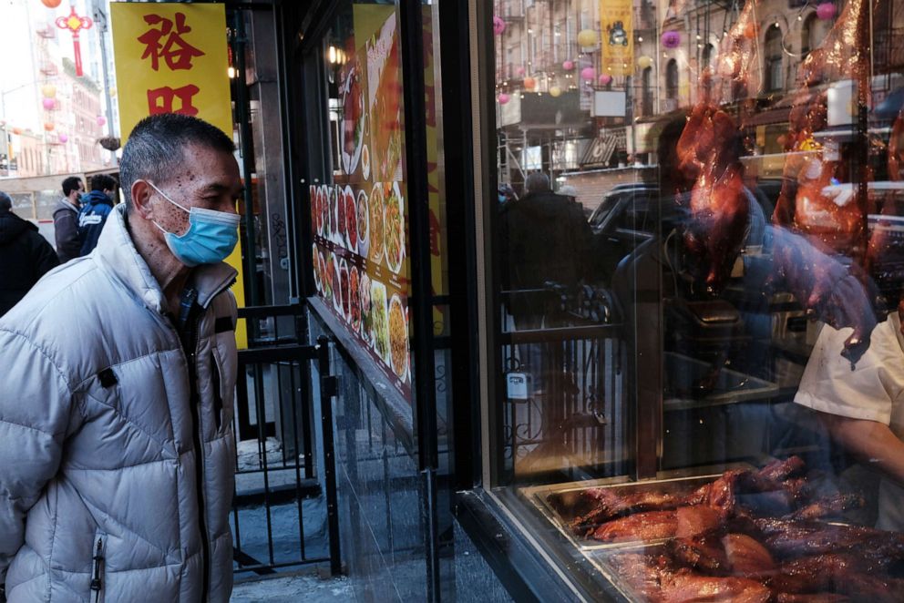 PHOTO: People walk through the streets of Chinatown on March 02, 2021, in New York.