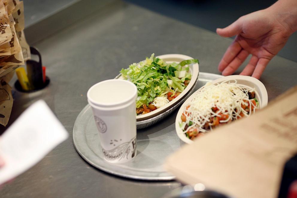 PHOTO: In this Feb. 2, 2019, file photo, an employee gives a customer burrito bowls on a tray at a Chipotle Mexican Grill Inc. restaurant in Louisville, Kentucky.