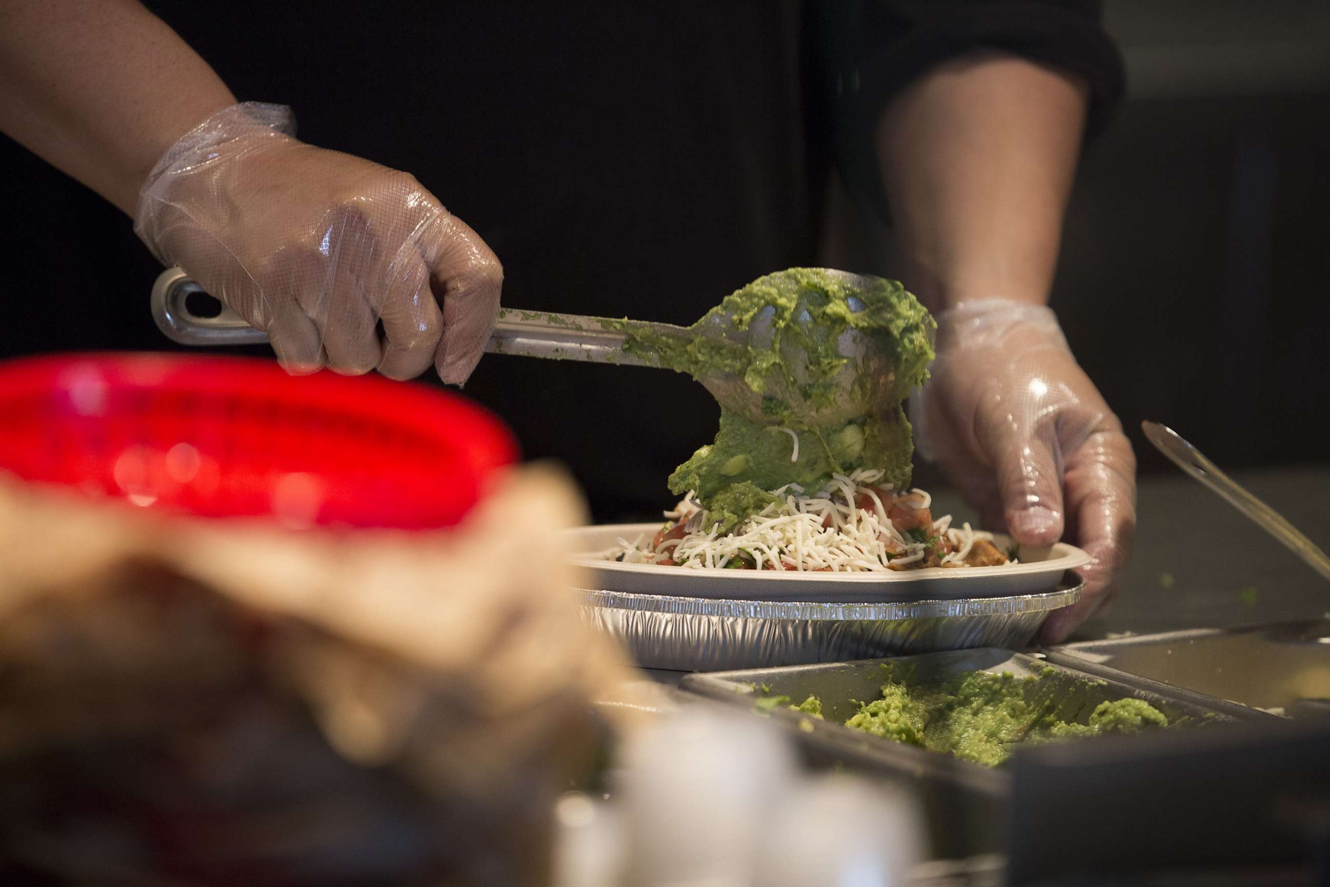 PHOTO: An employees places guacamole into a burrito bowl at a Chipotle Mexican Grill Inc. restaurant in Tempe, Ariz., Oct. 21, 2017.