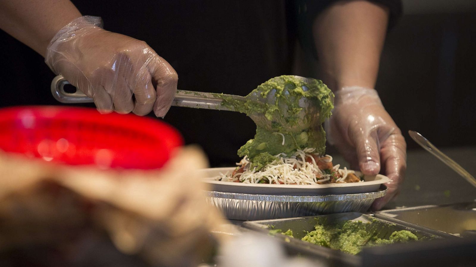 PHOTO: An employees places guacamole into a burrito bowl at a Chipotle Mexican Grill Inc. restaurant in Tempe, Ariz., Oct. 21, 2017.