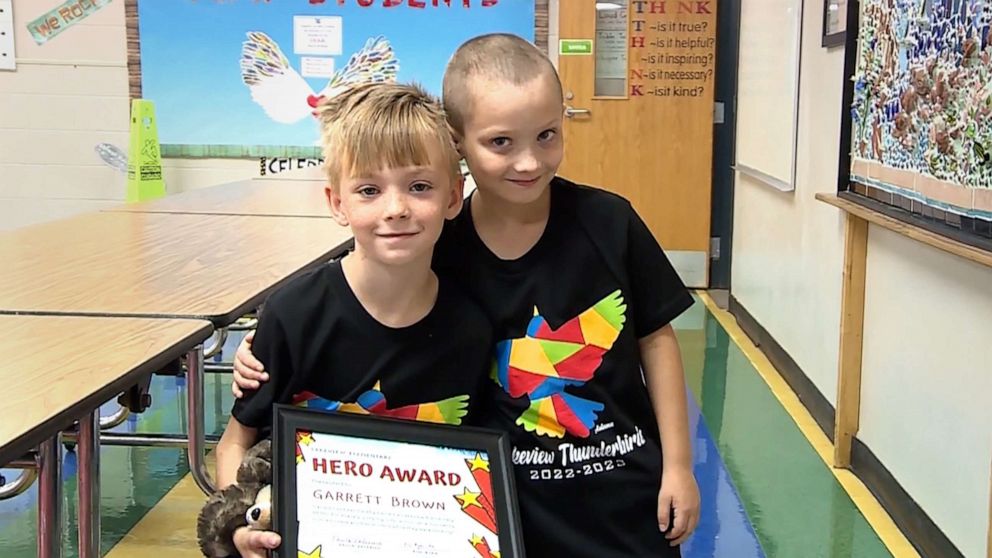 PHOTO: Garrett Brown holds his "hero award" certificate as Cashton York poses alongside him, at their school in Norman, Okla.