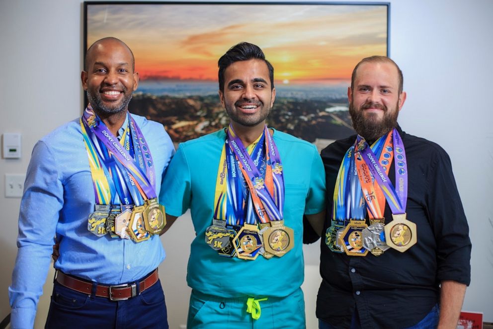 PHOTO: Christopher Hasty, right, poses with friends who completed the "Dopey Challenge" alongside him wearing all four medals.