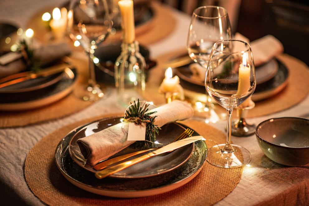 PHOTO: Close up of a Christmas table serving with burning candles at night.