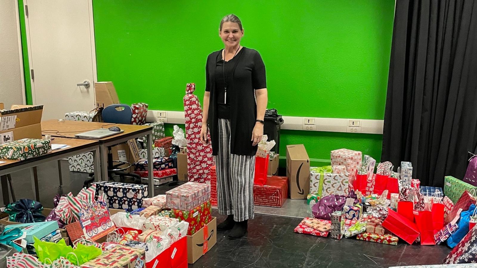 PHOTO: Cheri Guy, a teacher at Desert Pines High School in Las Vegas, stands with some of the hundreds of gifts donated for the school’s students.