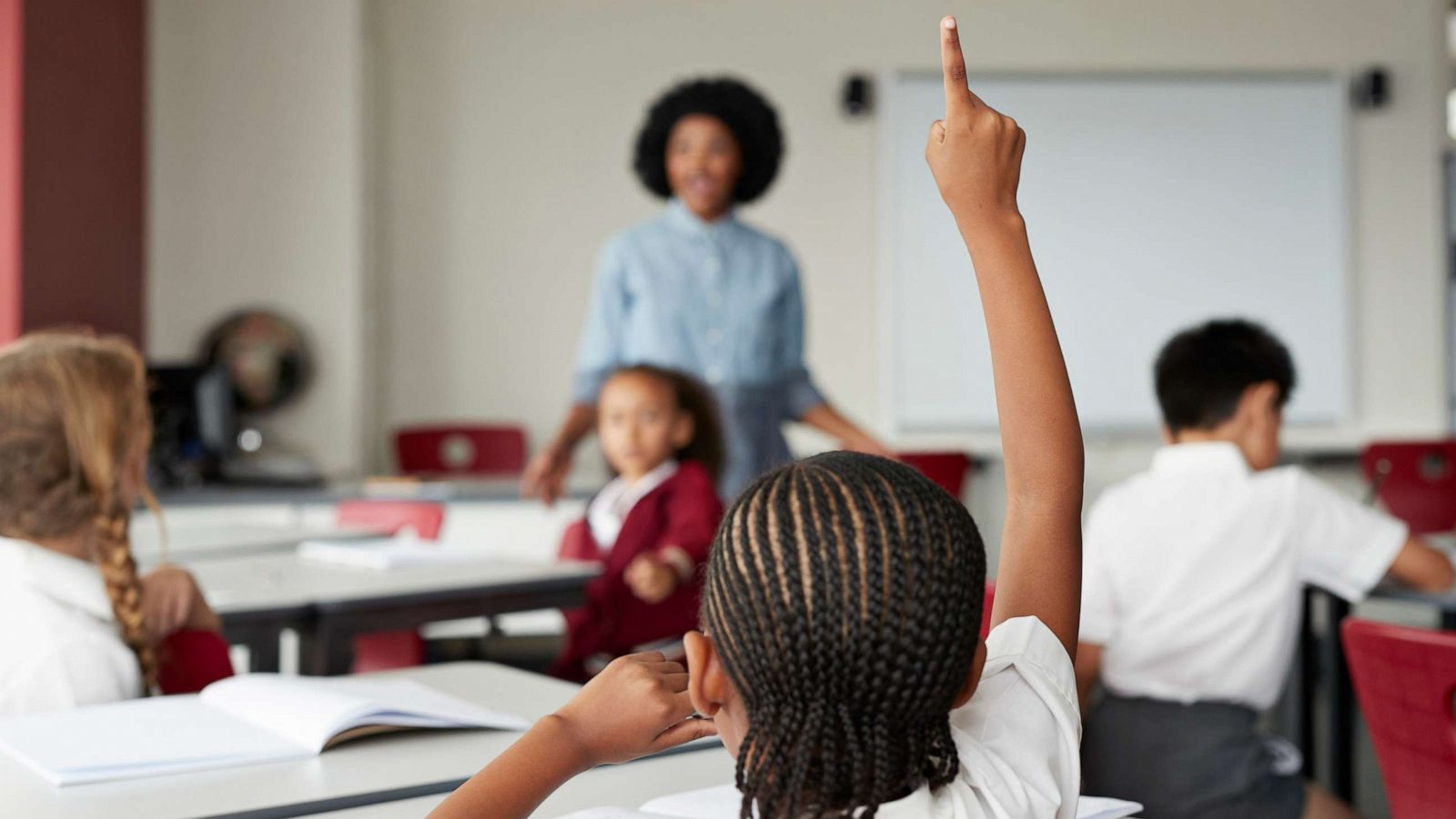 PHOTO: A child raises their hand during class in this stock photo.