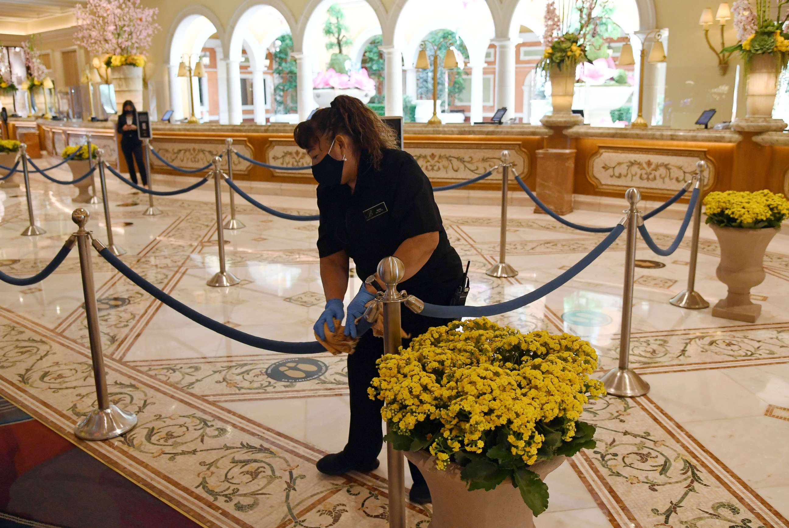 PHOTO: A worker cleans stanchions and ropes in the front desk area of Bellagio Resort & Casino on the Las Vegas Strip, June 4, 2020, in Las Vegas.