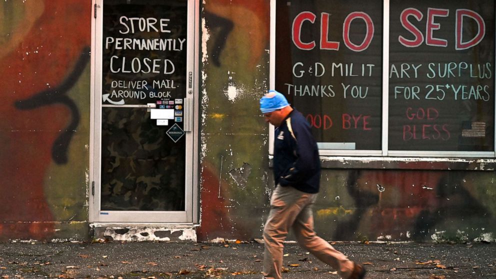PHOTO: A person passes a store that has closed permanently during the Coronavirus pandemic in Patchogue, N.Y. on Nov. 12, 2020.