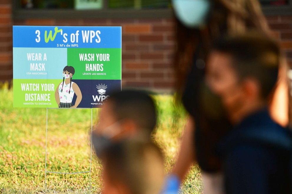 PHOTO: Students wearing masks walk to the main entrance of Hodgkins Leadership Academy on first day of school in Westminster, Colo., Aug. 20, 2020.