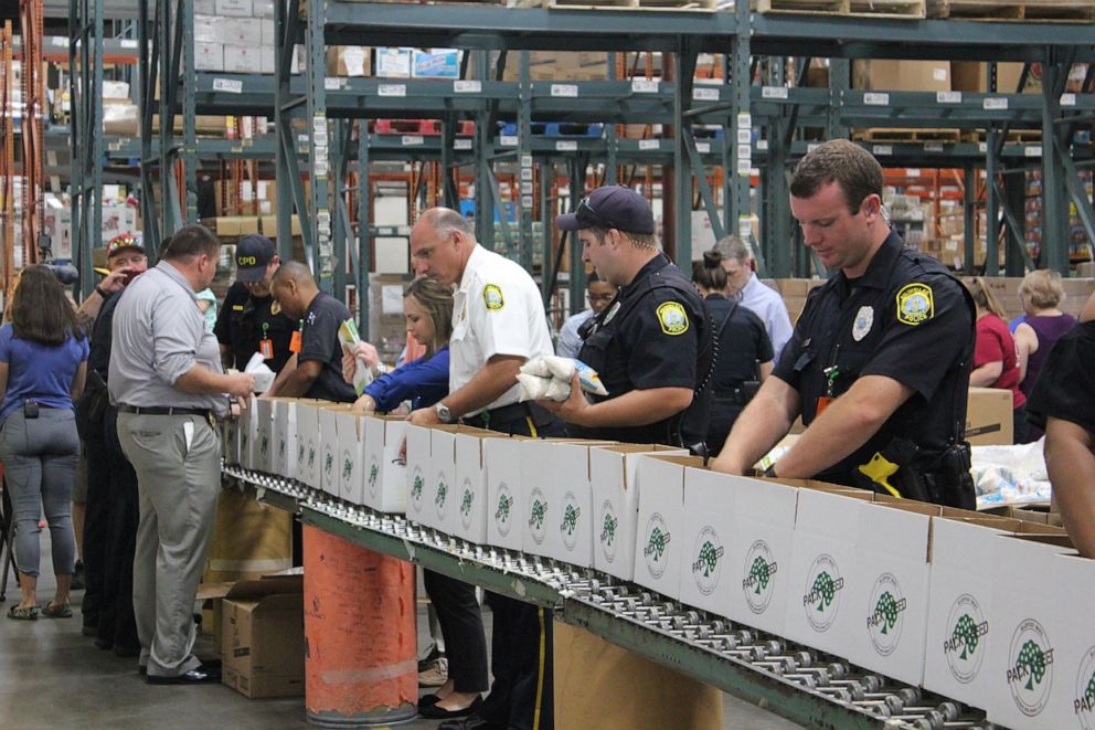 PHOTO: Columbia PD Chief W.H. "Skip" Holbrook, in white, packs boxes of groceries at a Greg's Groceries event.