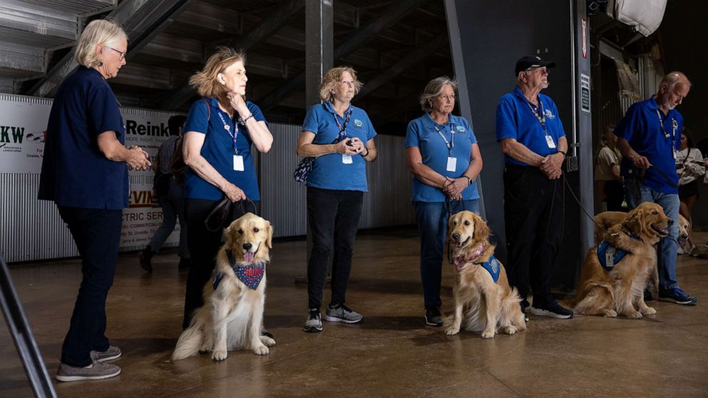 PHOTO: Volunteers with comfort dogs from Lutheran Church Charities offer their services to mourners at a vigil, May 25, 2022, for the 21 people killed at Robb Elementary School on May 24 in Uvalde, Texas.