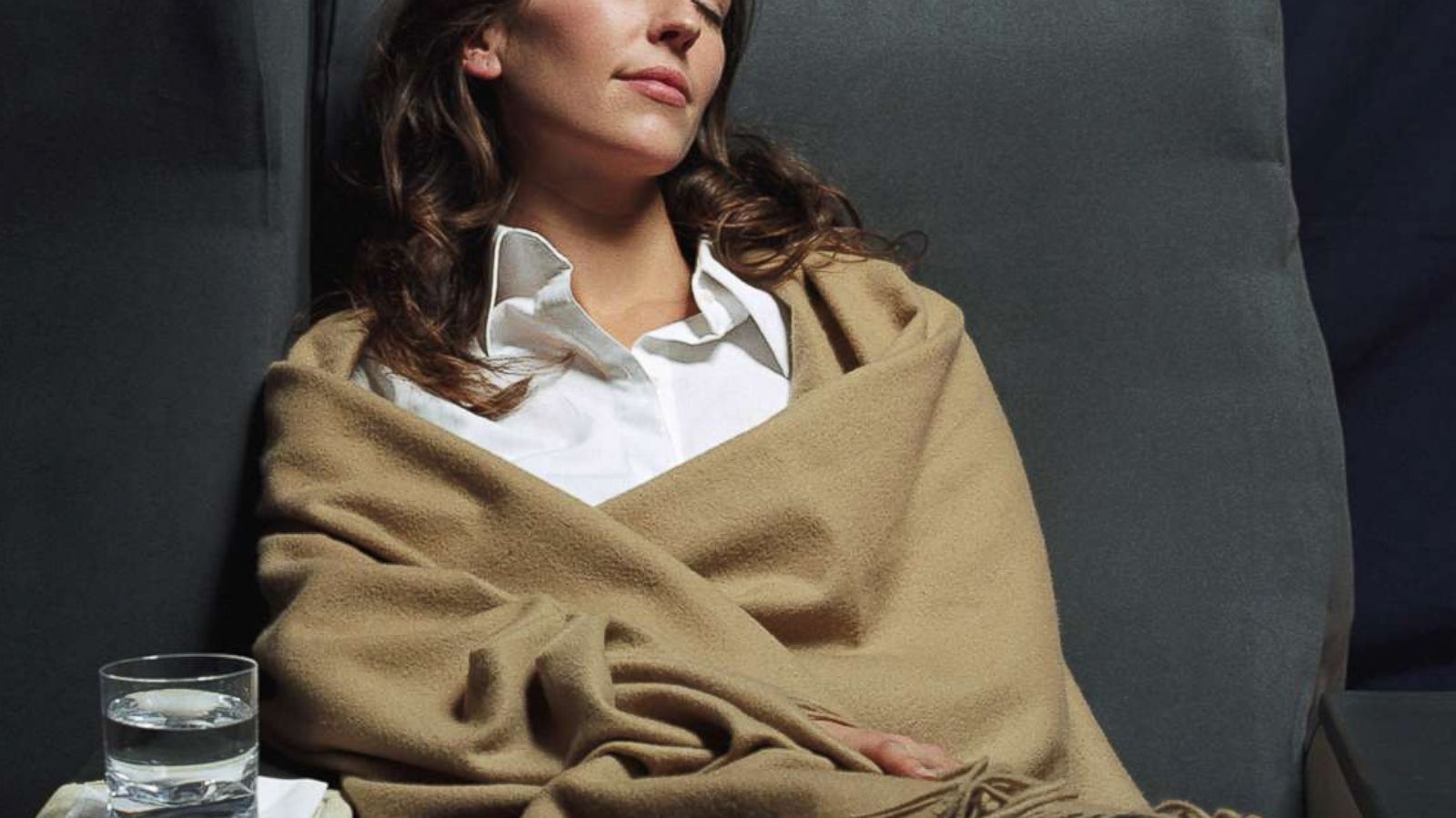 PHOTO: A stock photo depicts a woman relaxing comfortably on an airplane.